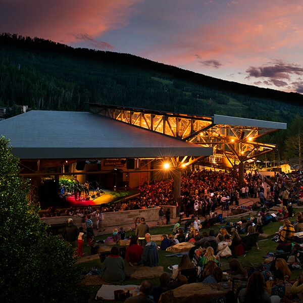 An outdoor concert at dusk in the mountains.