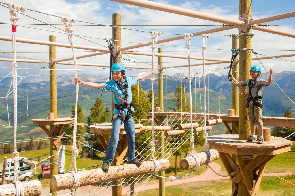 A family on a mountain vacation at a ropes course.
