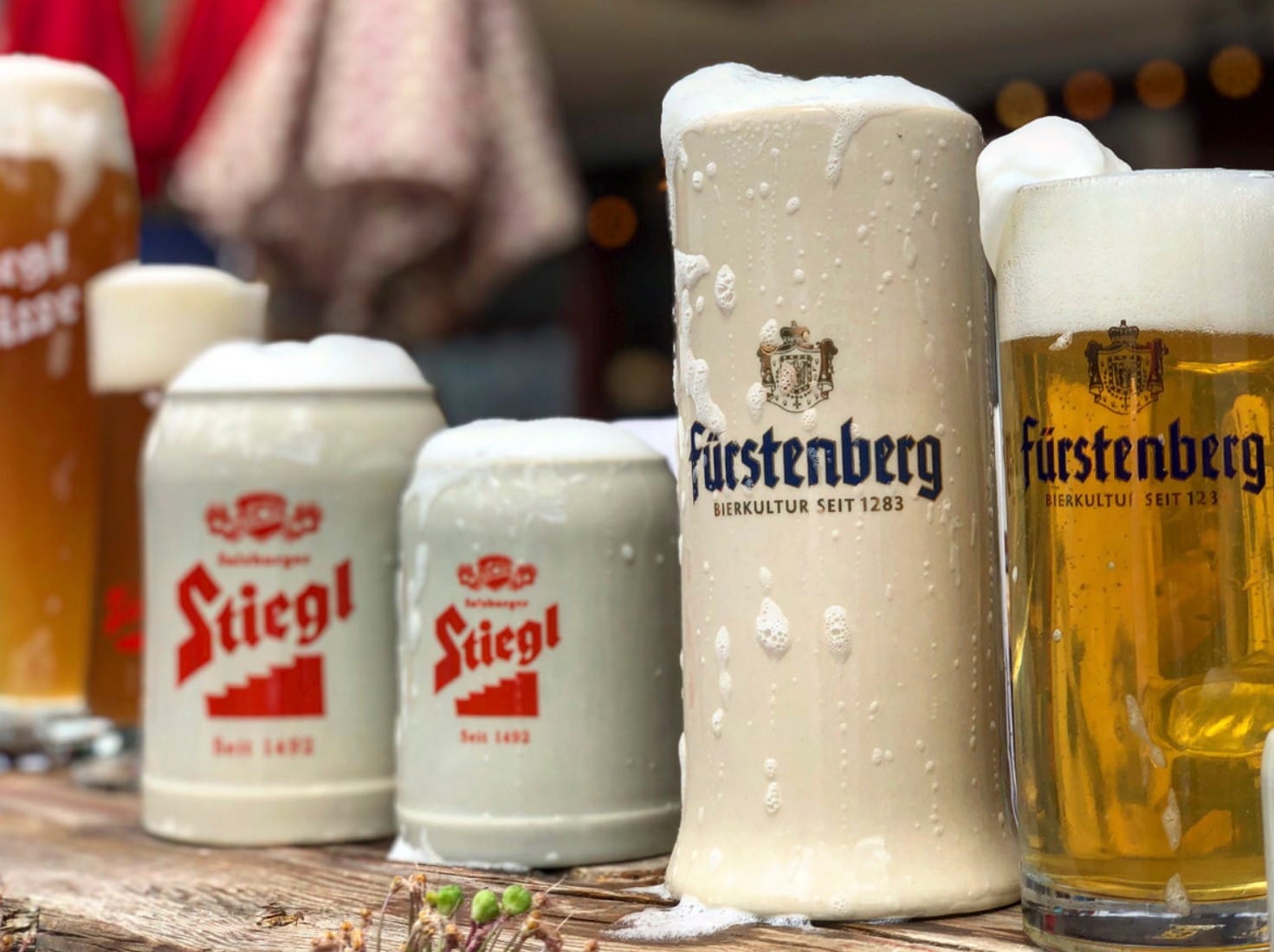 German beer steins sit in a row with frothy foam spattered across the glassware in Vail.