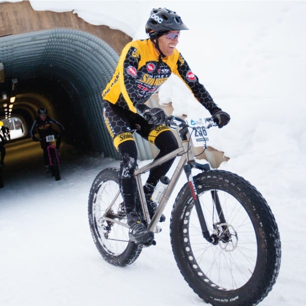 A man riding a fat bike through a tunnel.