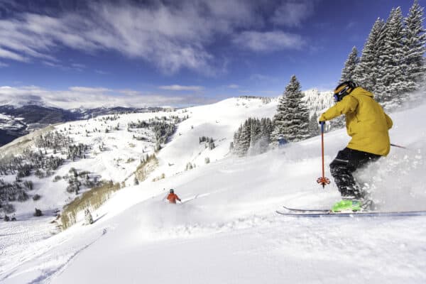Welcome to Vail, where a person is skiing down a snowy slope.