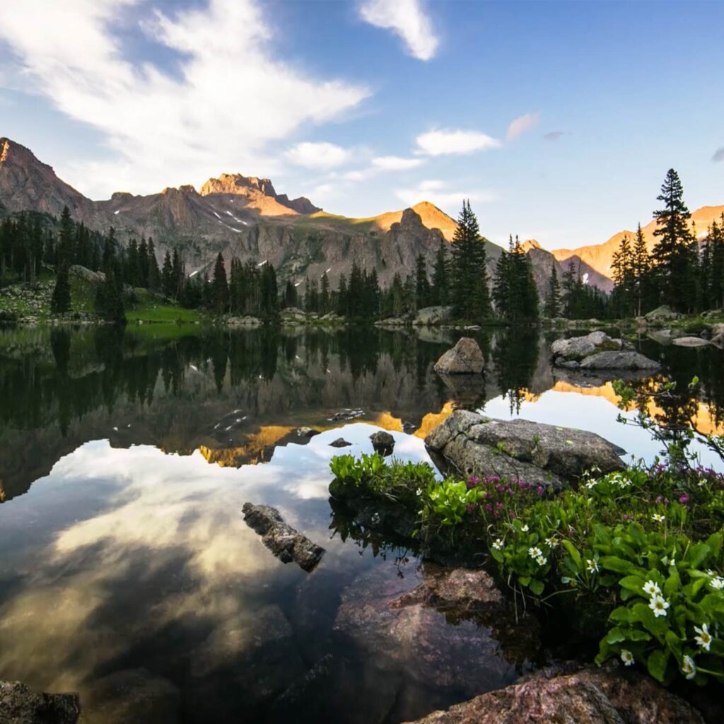 A picturesque lake nestled amidst majestic mountains and lush trees in Beautiful Vail.