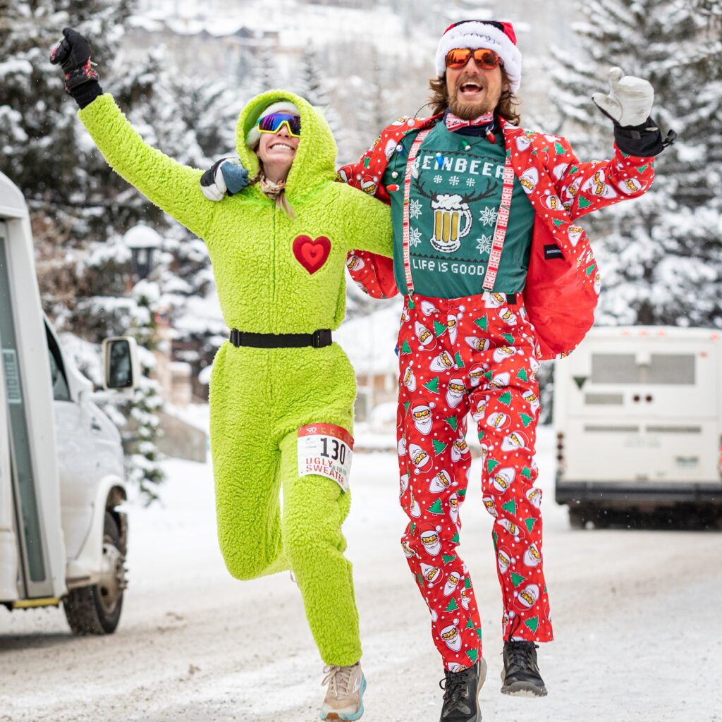 A man and a woman dressed up in santa suits.