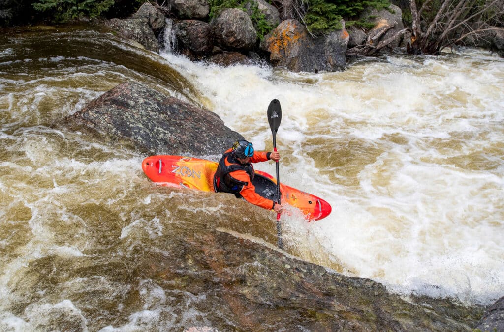 kayaker paddles down river