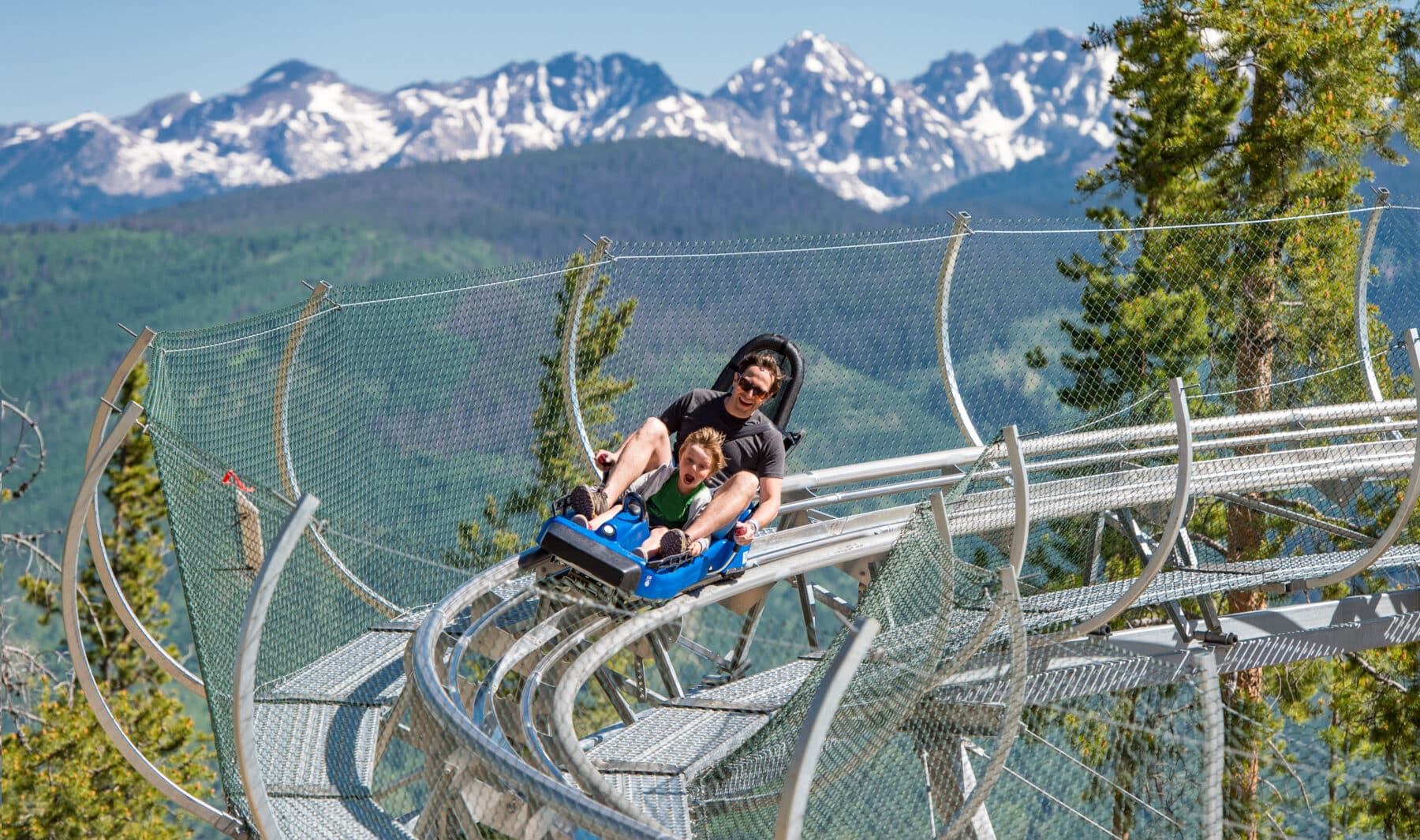 A parent and their child zip around the curved track of the alpine coaster at Epic Discovery near Vail, Colorado.