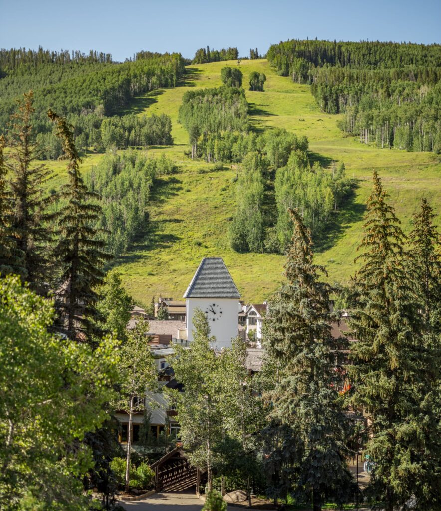 Grassy mountain runs are seen above the Vail Village in Colorado, winding between stands of trees