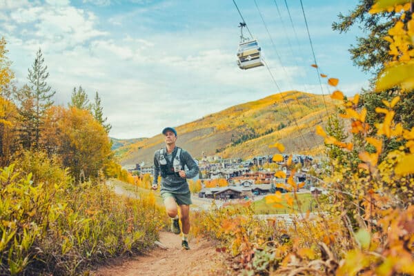 a man running on vail mountain in the fall