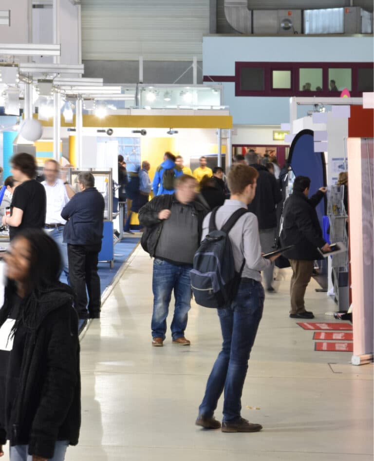 Visitors move throughout a large convention center during a brand showcase event.