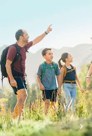 Family hiking together on a mountain trail in Vail with Gore Range in background