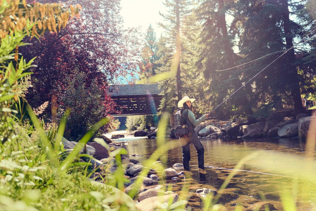Woman fly fishing in gore creek in vail