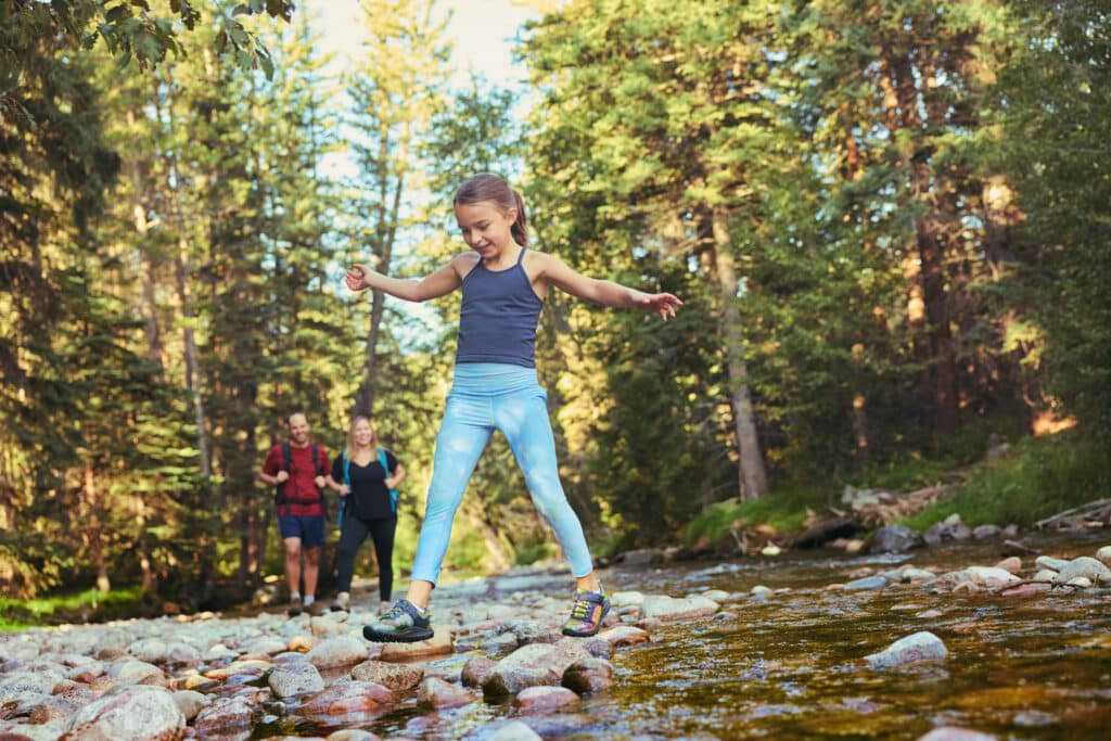 Family hikes along riverbed in Vail