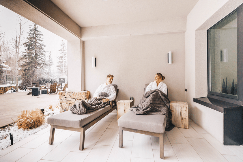 Two people relaxing at a Vail spa on a snowy winter day